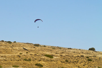 Fototapeta na wymiar Paraglider in the sky above a mountain slope