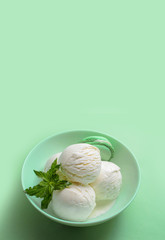Balls of fresh ice cream with a sprig of mint and mint macaroon.