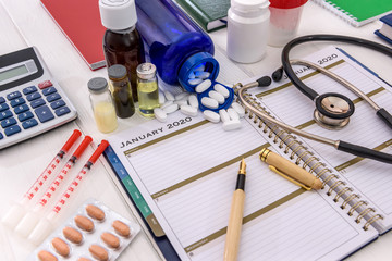 Medicaments with diary on the table close up