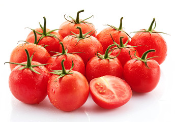 Ripe tasty red tomatoes with dew drops on a white background.