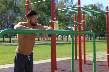 Obraz premium Muscular athlete relaxing after intense workout outdoors