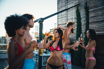 Group of friends having fun on the rooftop of a beautiful penthouse