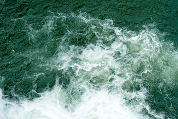 Fototapeta na wymiar Bubbling water of a mountain river. Bubbling water flowing down a mountain river