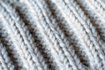 Extreme close-up gray color knitted sweater made of natural wool texture, wavy folds, selective focus