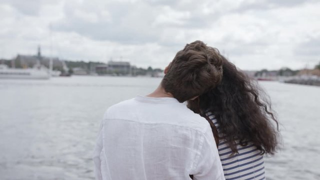 A young loving couple kissing at the water in Stockholm centre.