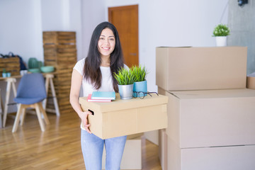 Fototapeta na wymiar Young beautiful woman moving cardboard boxes at new home