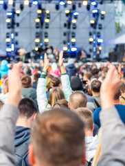 many different people at a concert listening to rock band music open air