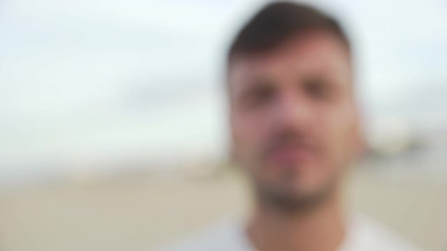Closeup of handsome young man shoting saying no in slow motion approaching at the camera.