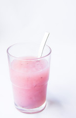 Drinking yogurt in a glass on a white background, copy space. Delicious pink fruit yogurt. Natural detoxification. Healthy eating concept. Fresh homemade yogurt for Breakfast. Fruit yogurt smoothie.