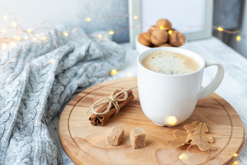 Obraz na płótnie Canvas Coffee mug, sweater, cinnamon, decorated with led lights. Autumn mood. Cozy autumn composition. Hygge concept Soft focus - Image