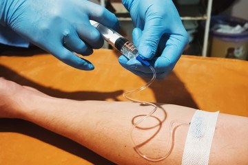 Doctor's hands with a syringe for injection to the patient.