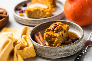 Pumpkin cake with walnuts, cinnamon and maple syrup on plate. Autumn comfort food. Sweet cake