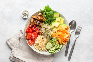 Trendy colorful vegan buddha bowl salad with fried tofu, carrot, cucumber, bulgur avocado tomato and green salad leaf on grey concrete background. Top view. Balanced diet food - 289918366