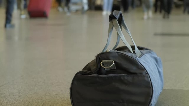 bag of explosives left by terrorist at the airport. sports bag on floor at the airport on the background of walking crowd of passengers. time lapse.