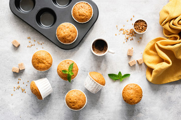 Homemade delicious vegetarian muffins with brown sugar on grey concrete background, flat lay, top view