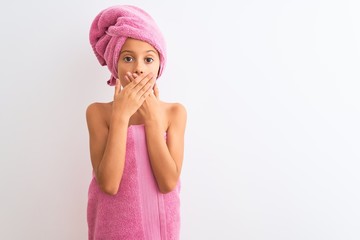 Beautiful child girl wearing shower towel after bath standing over isolated white background shocked covering mouth with hands for mistake. Secret concept.