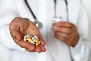 Doctor giving pills, physician holding in palm of hand medication in capsules. Concept of dose of drugs during cold season, vitamins, medical exam, pharmacy