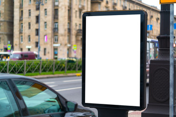 White vertical billboard on the lawn near the road with white mockup background advertising field. standing in the city