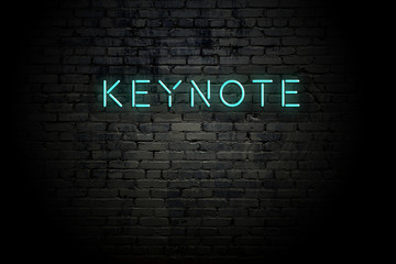 Highlighted brick wall with neon inscription keynote