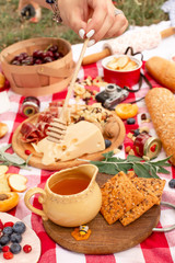 Stylish picnic on the green lawn. Fresh croissants and a teapot with tea on a bedspread near a wicker female hat. Instagram content