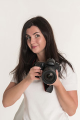 Fototapeta premium Young brunette woman - professional photographer with DSLR camera on white background