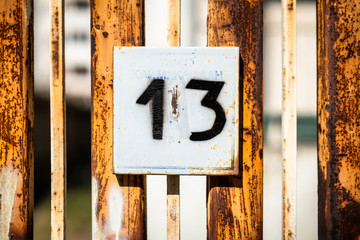 Number 13, thirteen, street number sign on the wall	