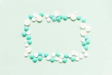 Turquoise, cyan, neo mint colorful chocolate candies isolated on neo mint background. Heap of candies multi colored against a neo mint texture. Top view or flat lay. Color of the year 2020. Main trend