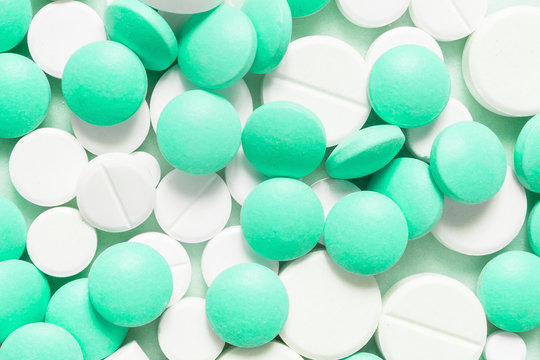 Turquoise, cyan, neo mint colorful chocolate candies isolated on neo mint background. Heap of candies multi colored against a neo mint texture. Top view or flat lay. Color of the year 2020. Main trend