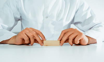 The doctor holds a empty block in his hand. Medical and pharmaceutical concept. A man wearing a white coat and stethoscope heals.