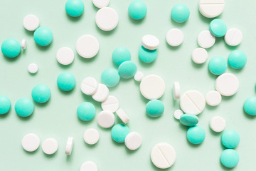 Turquoise, cyan, neo mint colorful chocolate candies isolated on neo mint background. Heap of candies multi colored against a neo mint texture. Top view or flat lay. Color of the year 2020. Main trend