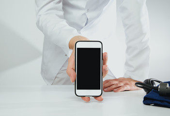 The doctor holds a phone with a blank display. Medical and pharmaceutical concept. The concept of showing medical information on the screen of a mobile phone.