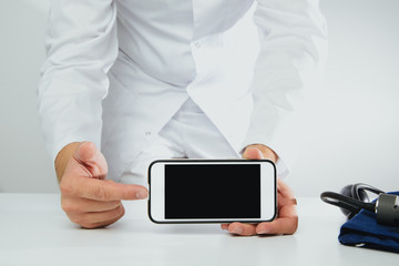 The doctor holds a phone with a blank display. Medical and pharmaceutical concept. The concept of showing medical information on the screen of a mobile phone.