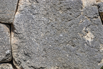 The ancient megalithic walls surround the acropolis of Amelia, in Umbria, Italy. Texture composed of huge blocks of stone, with irregular boulders interlocked together.