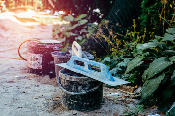 Trowel in front of the construction site. The concept of building, building a house, apartment. Equipment when building your own home. Renovation, improving the comfort of living in the apartment.