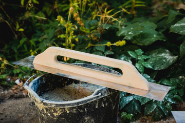 Trowel in front of the construction site. The concept of building, building a house, apartment. Equipment when building your own home. Renovation, improving the comfort of living in the apartment.