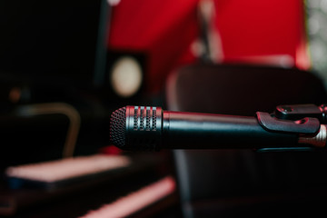 Recording microphone. Music concept. Record sound, music. Making music, recording. Creating sound foundations. Black microphone on a red background in the recording room.