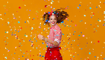 cheerful funny young woman with festive confetti on yellow - obrazy, fototapety, plakaty