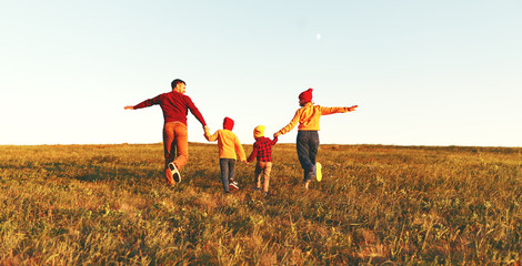 Happy family: mother, father, children son and daughter on autumn sunset