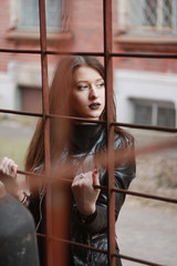 Fototapeta premium Woman wear on a leather jacket, black dress and tights in grunge gothic style outdoors