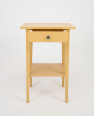 Wooden yellow nightstand with opened drawer on white isolated background 