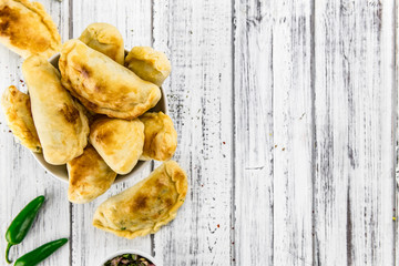 Wooden table with Empanadas (detailed close-up shot; selective focus)