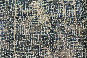 Background in the form of a knitwear product with a pattern similar to the skin of a snake in various shades of brown and gray