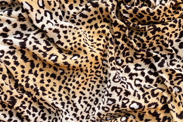 Background in the form of a knitwear product with a pattern similar to a leopard skin in cream brown tones with wavy lines