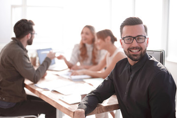 smiling businessman in the background of the office.