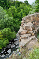 Green trees in a canyon against a cloudy sky background