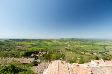 Fototapeta na wymiar Tuscan countryside with farms and green grass, as seen from above