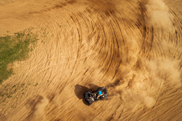 Aerial view of Quad bikes driving in the sand .