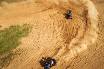 Aerial view of Quad bikes driving in the sand .