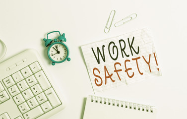 Writing note showing Work Safety. Business concept for policies and procedures in place to ensure health of employees Blank paper with copy space on the table with clock and pc keyboard