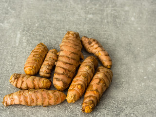 Group of curcuma roots on gray. Selective focus.
